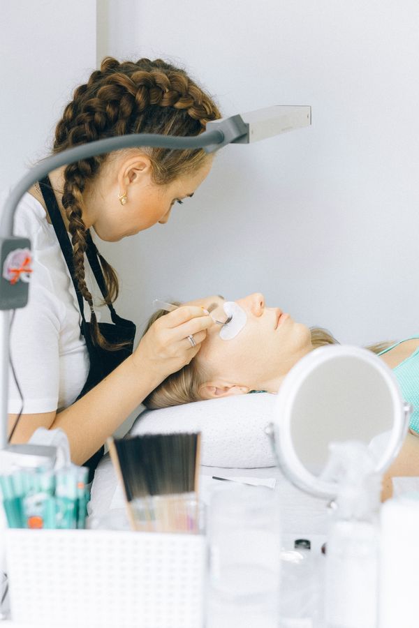 Lash artist carefully applying extensions in a bright, clean studio